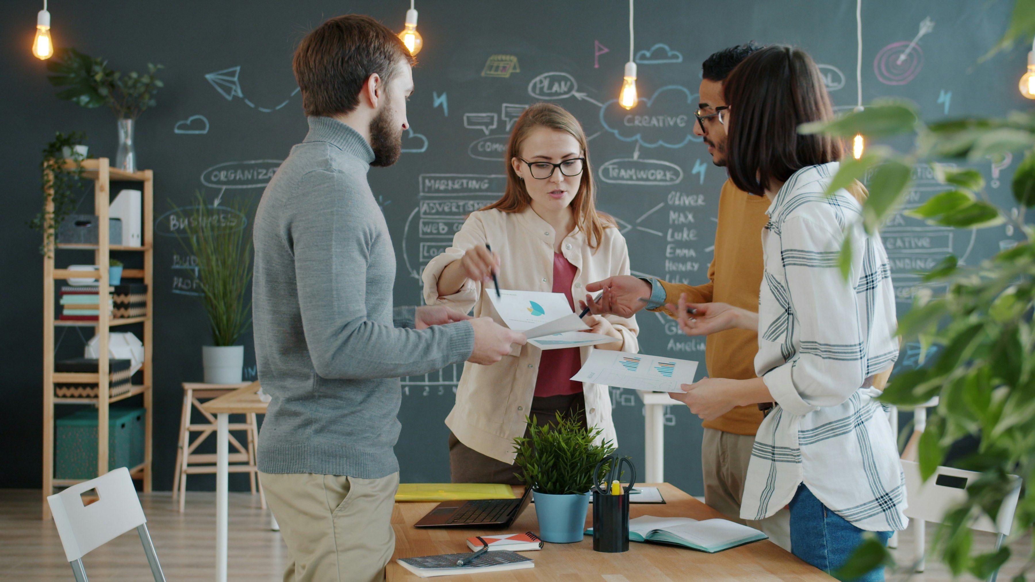 Une équipe de créateurs d’entreprise travaille autour d’une table, dans un espace de travail lumineux.